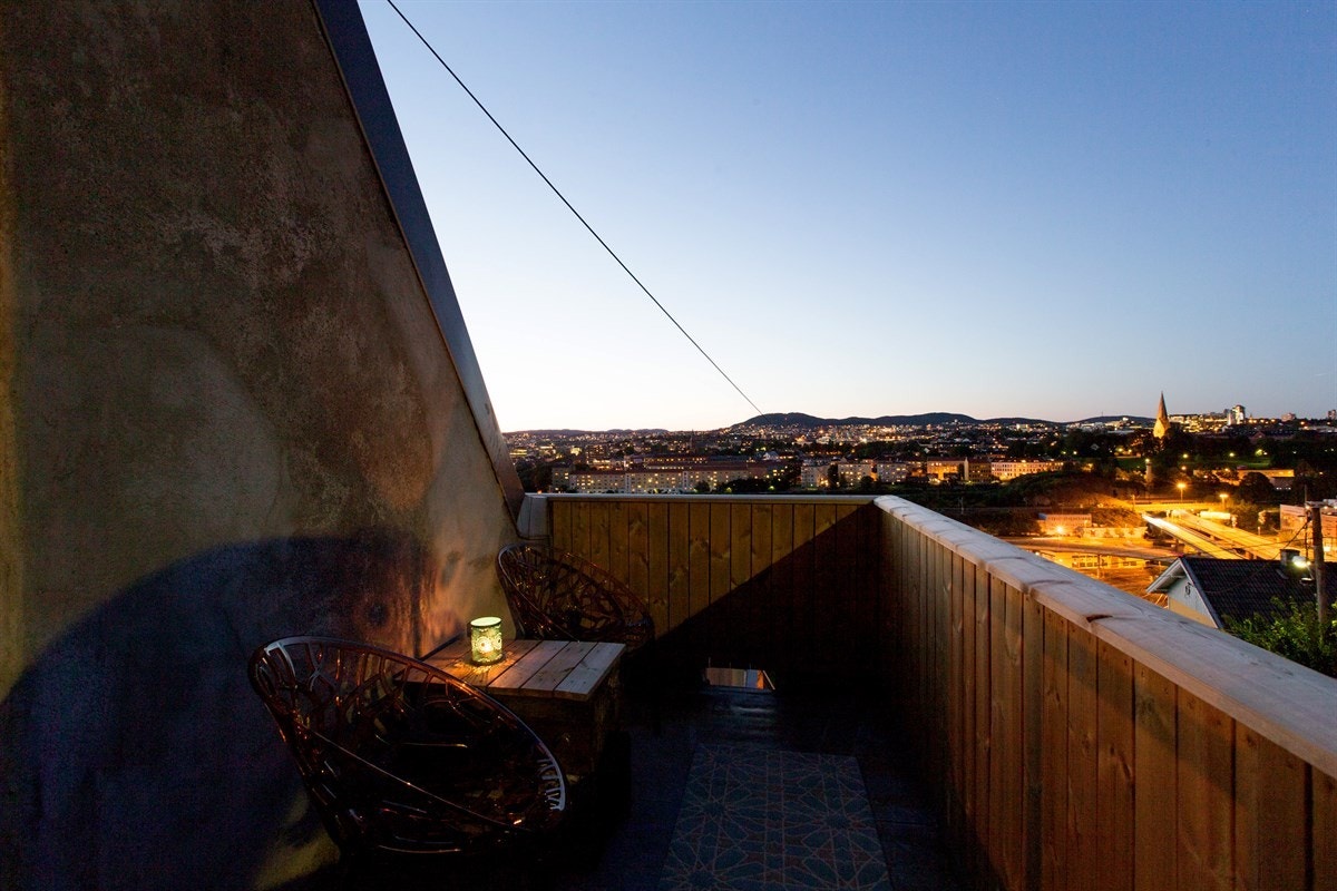 Kveldsstemning på verandaen utenfor soverommet med Vålerenga kirke og Holmenkollen i bakgrunnen. Galleribilde
