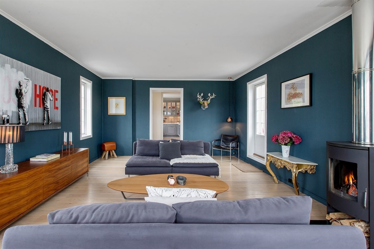 En moderne og effektiv peisovn står spent å venter på at vinteren skal komme. Se frem hvilke flotte vintersolnedganger stuen vil by på. På gulvet er det lagt en solid amerikansk eikeparkett. Galleribilde