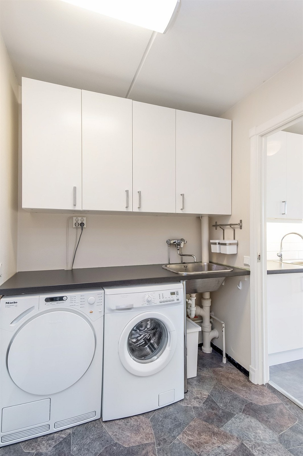 Praktisk innredet vaskerom med utslagsvask Galleribilde