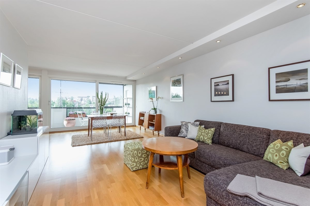 Lys og innbydende stue med store lysflater og utgang til veranda Galleribilde