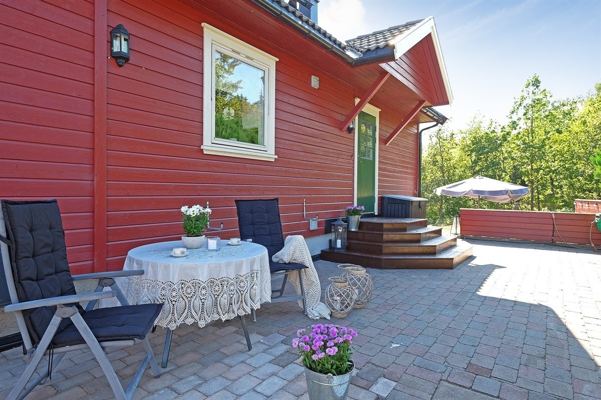 Steinsatt og lun terrasse på baksiden av huset - dette var inngangspariet før man bygde på huset Galleribilde