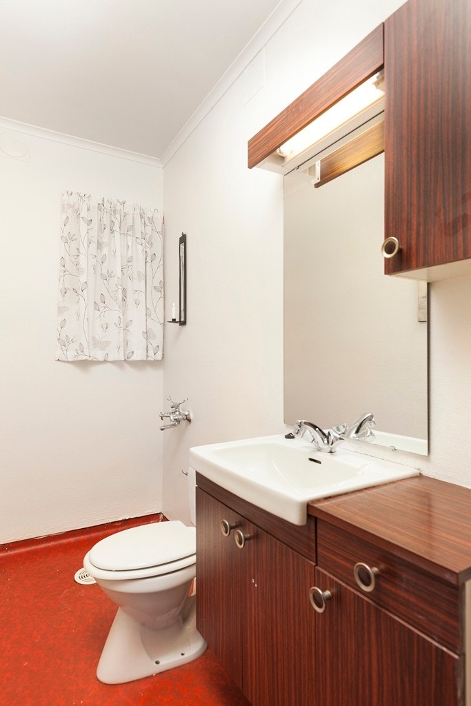 På badet i 1.etasje er det våtromsbelegg på gulv, malt strie på vegger og malt platekledning i himling. Badet inneholder servant med møblementspeil og belysning, toalett og dusjgarnityr. Galleribilde