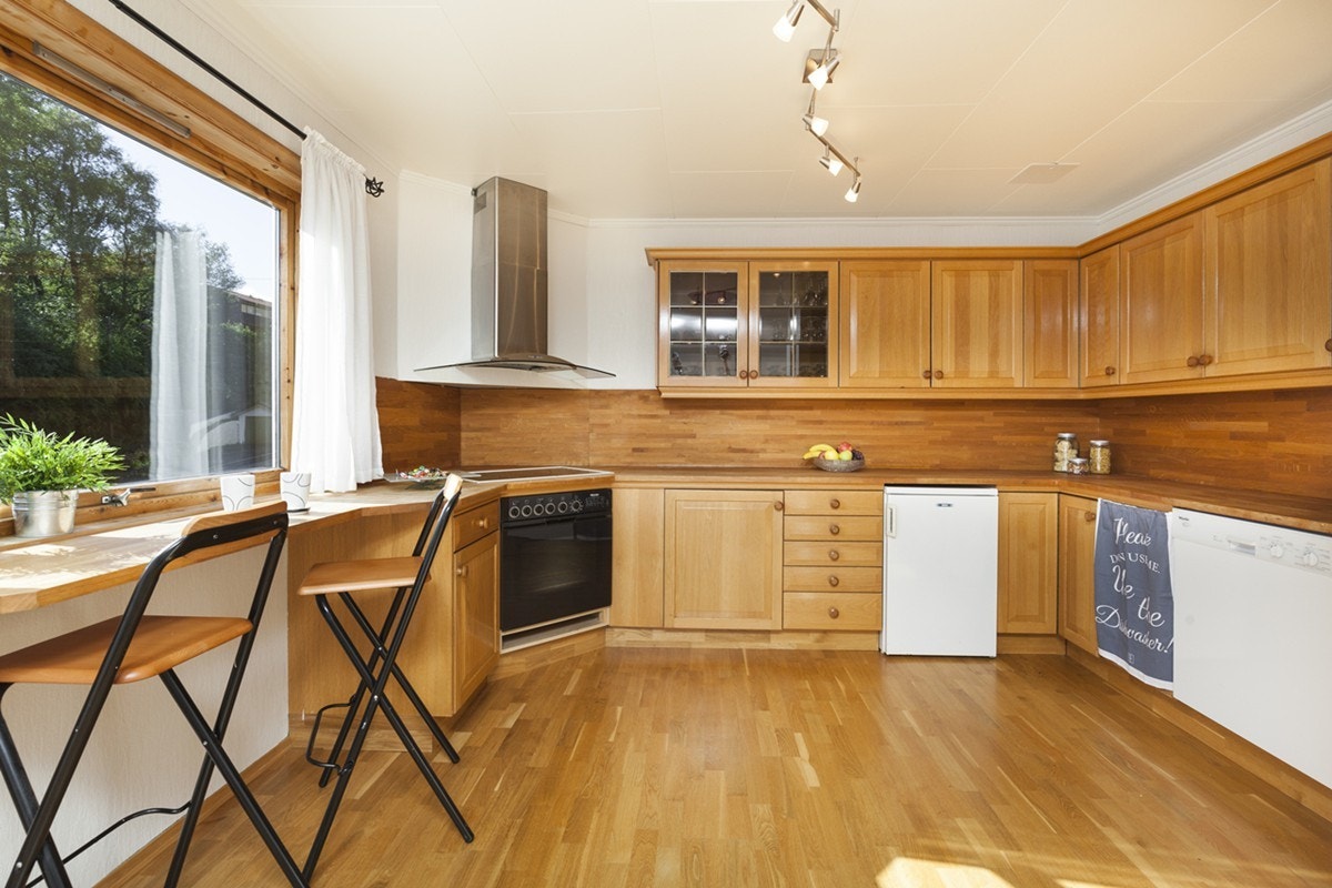 Kjøkkenet har parkett på gulv, malt strie på vegger og takplater i himling. Innredningen er Bolett med profilerte fronter og har et overskap med glassfront. Galleribilde