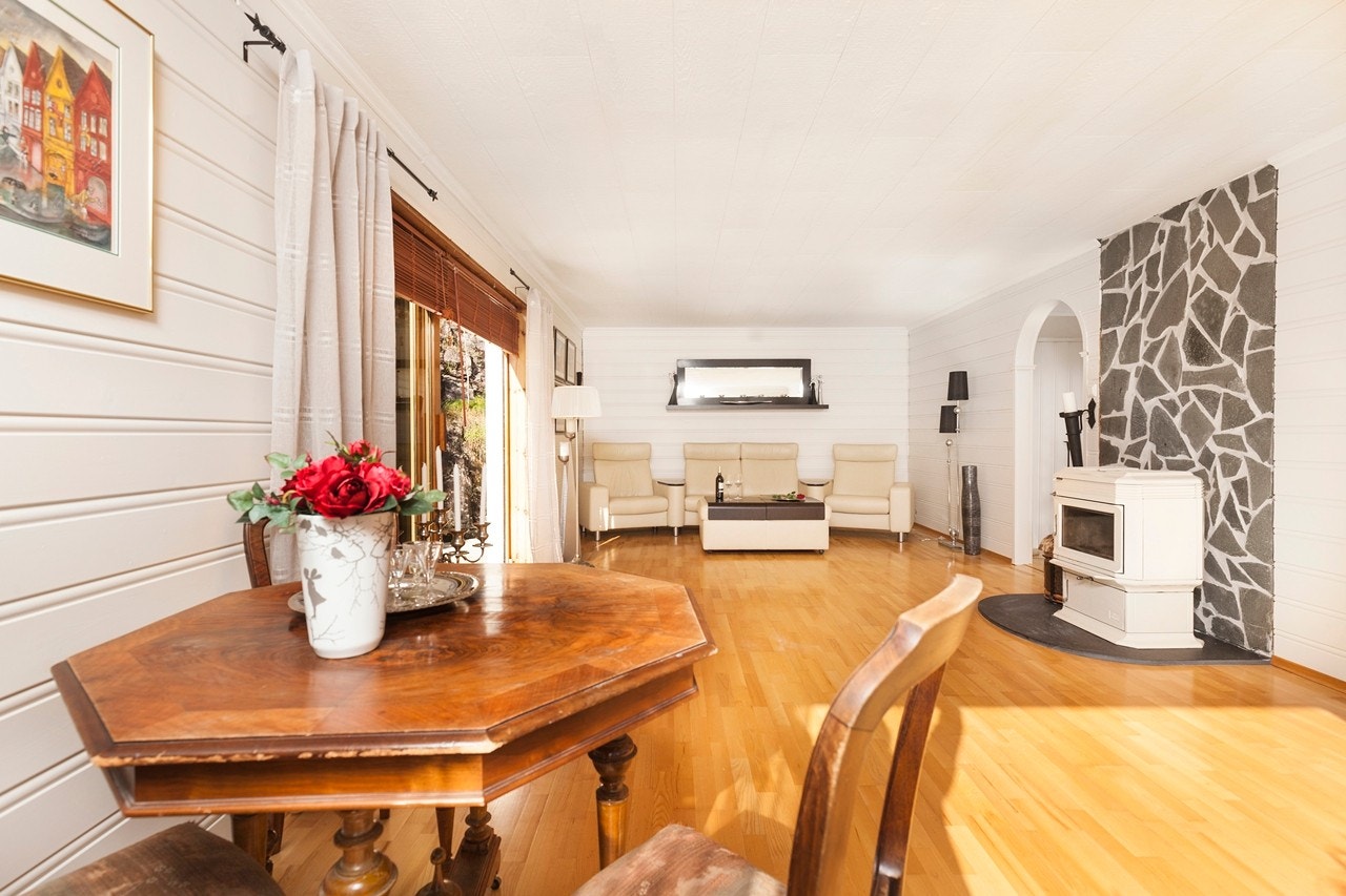 Veggene er lyse og innbydende samt at brytningen bak ovnen setter et moderne preg på stuen. Galleribilde