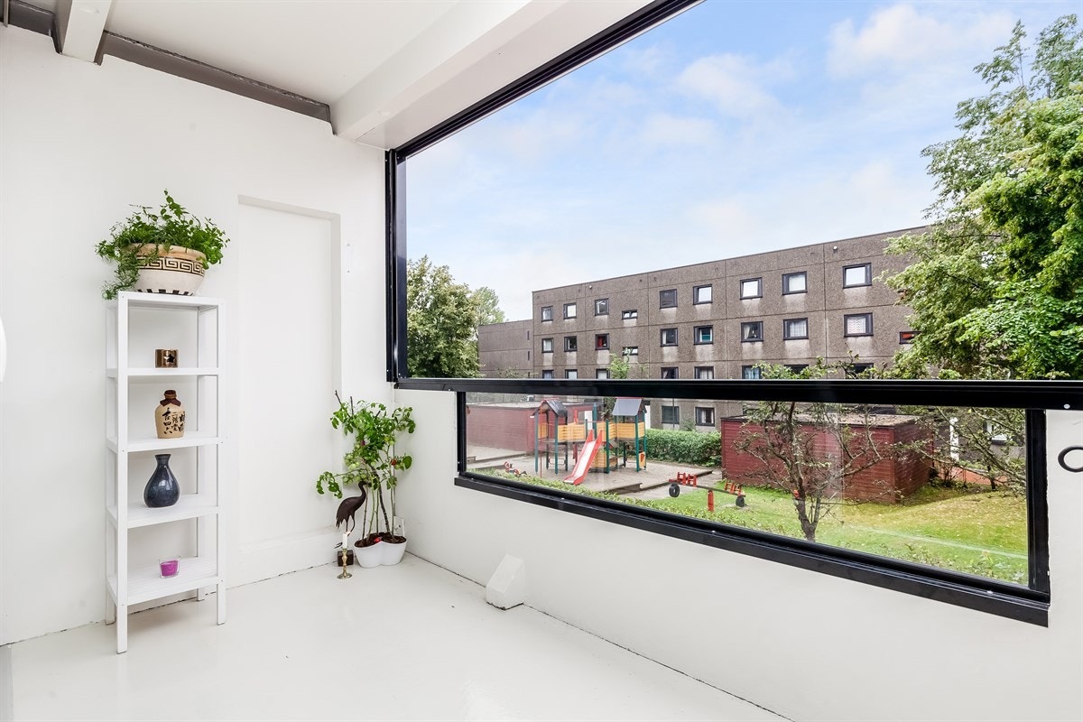 Verandaen er innglasset og har utsyn mot pent opparbeidede fellesarealer Galleribilde