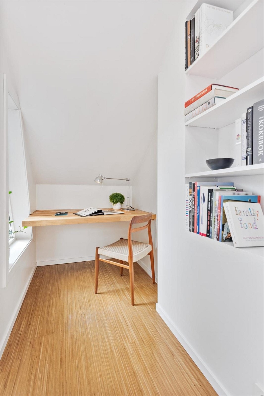 I hjørnet ved siden av takterrassen er det en hyggelig krok som passer perfekt som kontorhjørne eller lesekrok. Her er det et plasstilpasset skrivebord og en innfelt bokhylle. Galleribilde