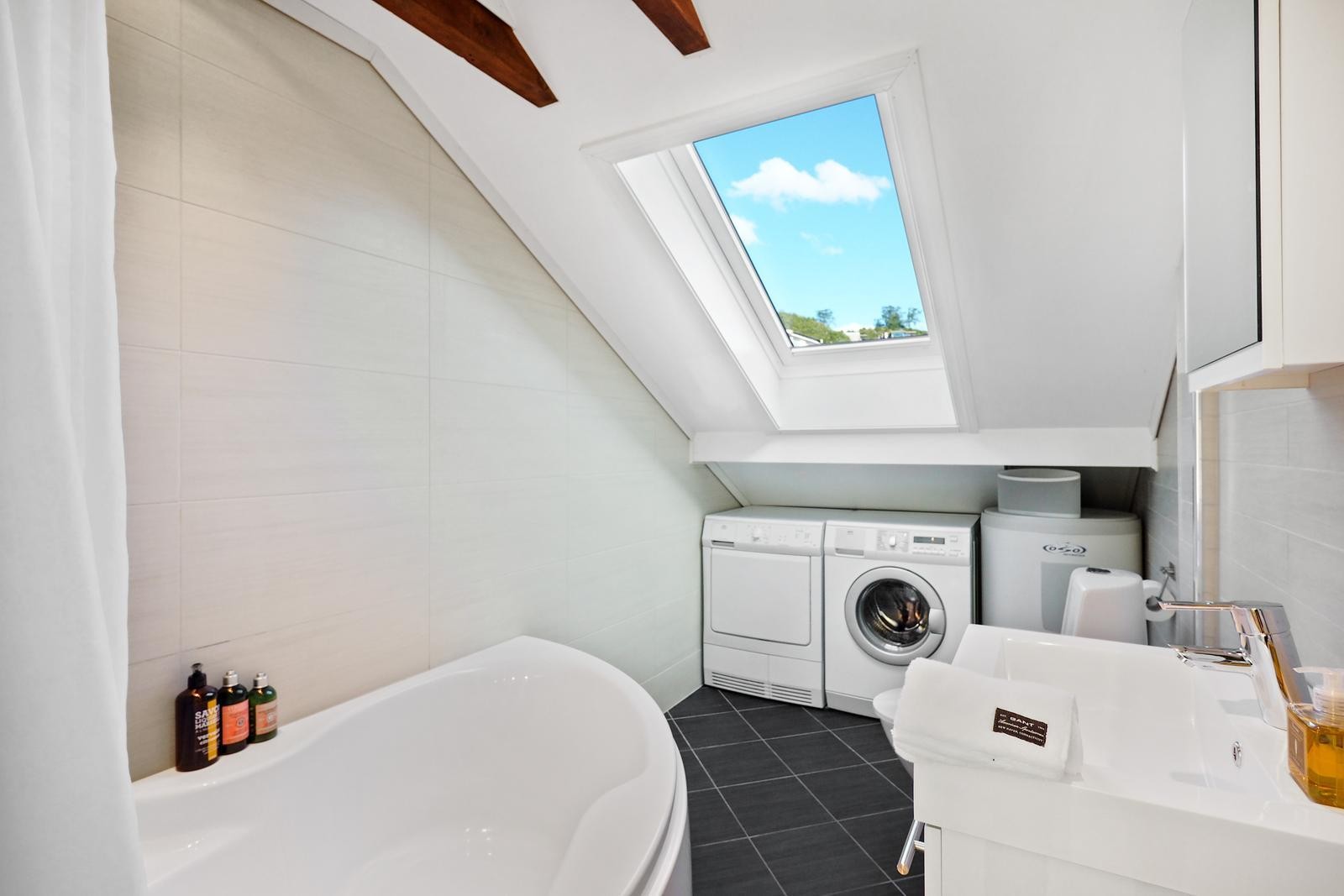 På badet er det opplegg til vaskemaskin og avsatt plass til tørketrommel. Takvindu sørger for godt med naturlig lys. Galleribilde
