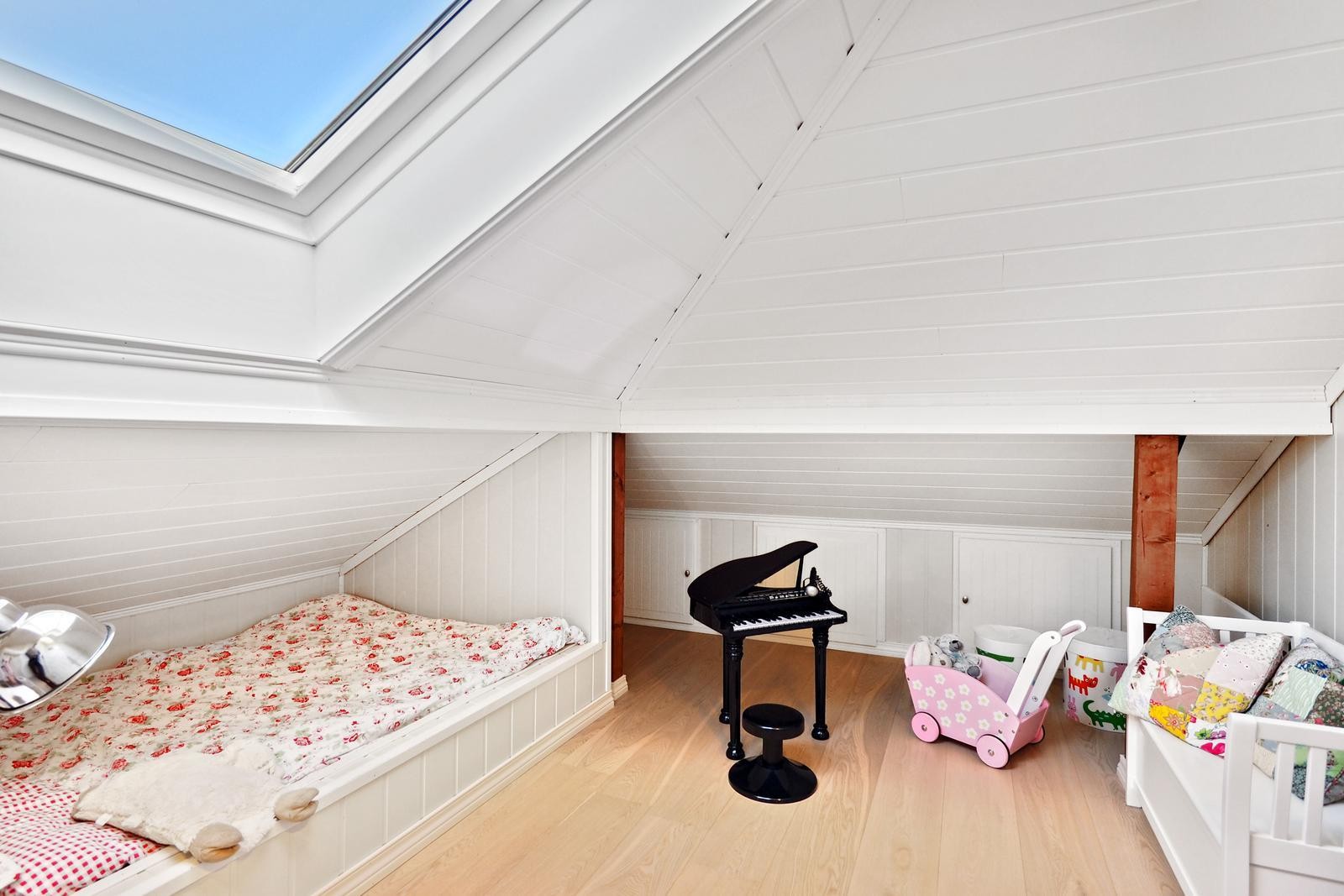 Disponibelt rom i loftsetasjen har en koselig innredet seng og godt med oppbevaringsplass i knevegg. Galleribilde