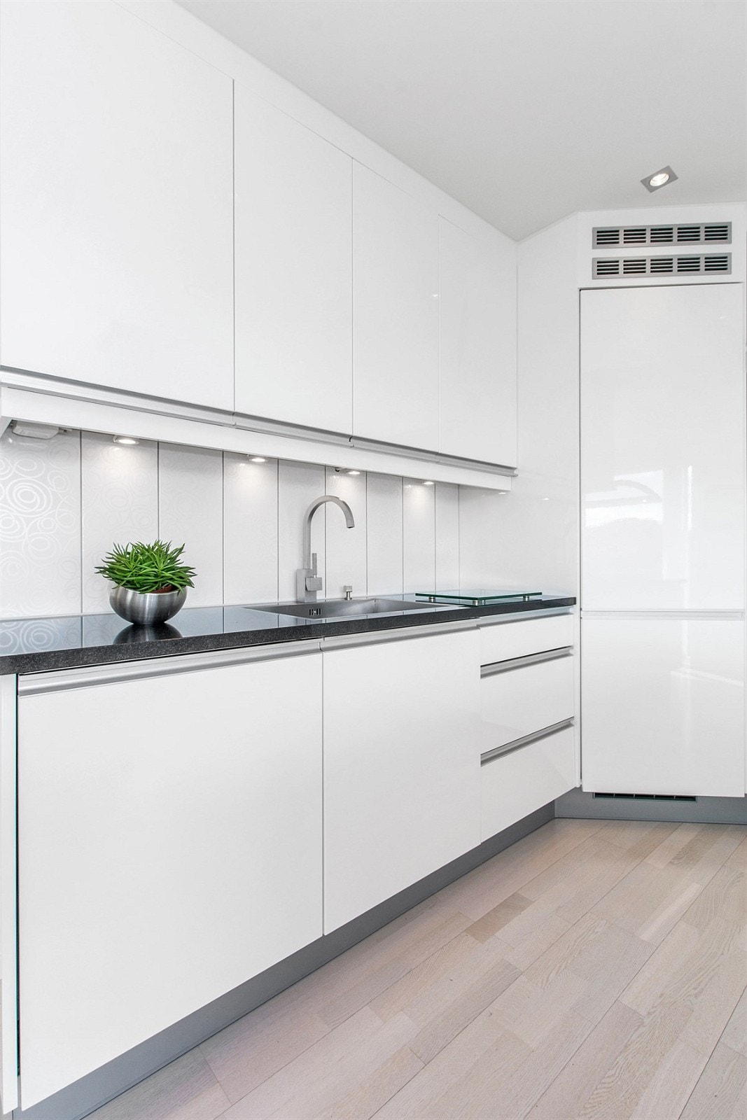 Er herlig benkeplate i sort stein skaper kledelig kontrast i den lyse rommet. Galleribilde