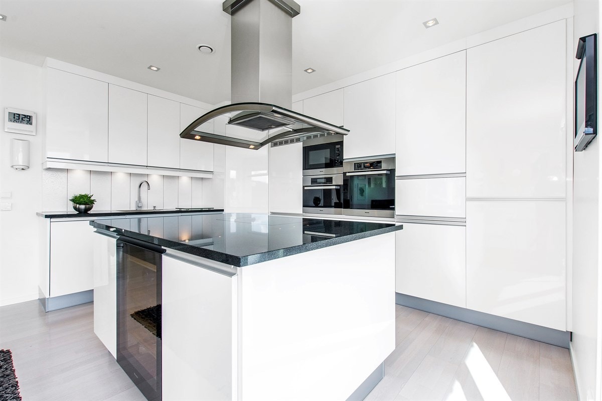 Stor og praktisk kjøkkenøy sørger for ekstra benkeplass og oppbevaringsmuligheter. Galleribilde