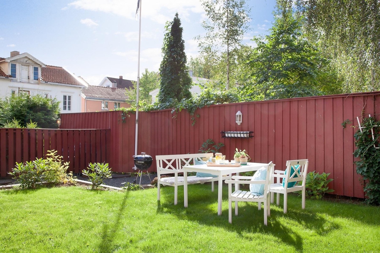 Idyllisk gårdsrom med beplantning, gressplen, sittegrupper m.m. Galleribilde