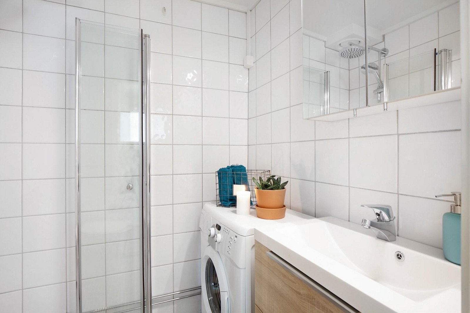 Flislagt bad med dusjplass med innfellbare dusjvegger, servant med underskap, overskap med speil og wc. Galleribilde