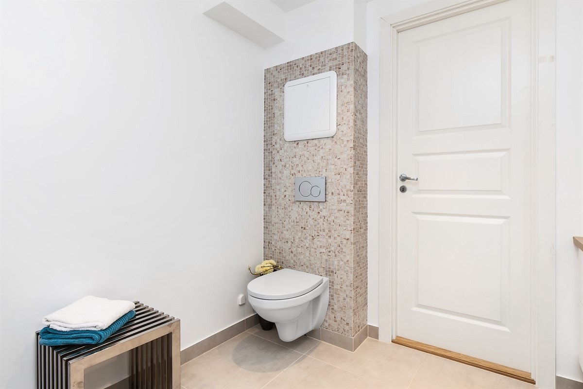 Badet er pusset opp de senere år og fremstår som meget delikat. Det er lyse fliser på gulv med gulvvarme, lysmalte vegger, samt sandfargede mosaikkfliser på vegg i dusjsonen og på innebygd sisterne Galleribilde