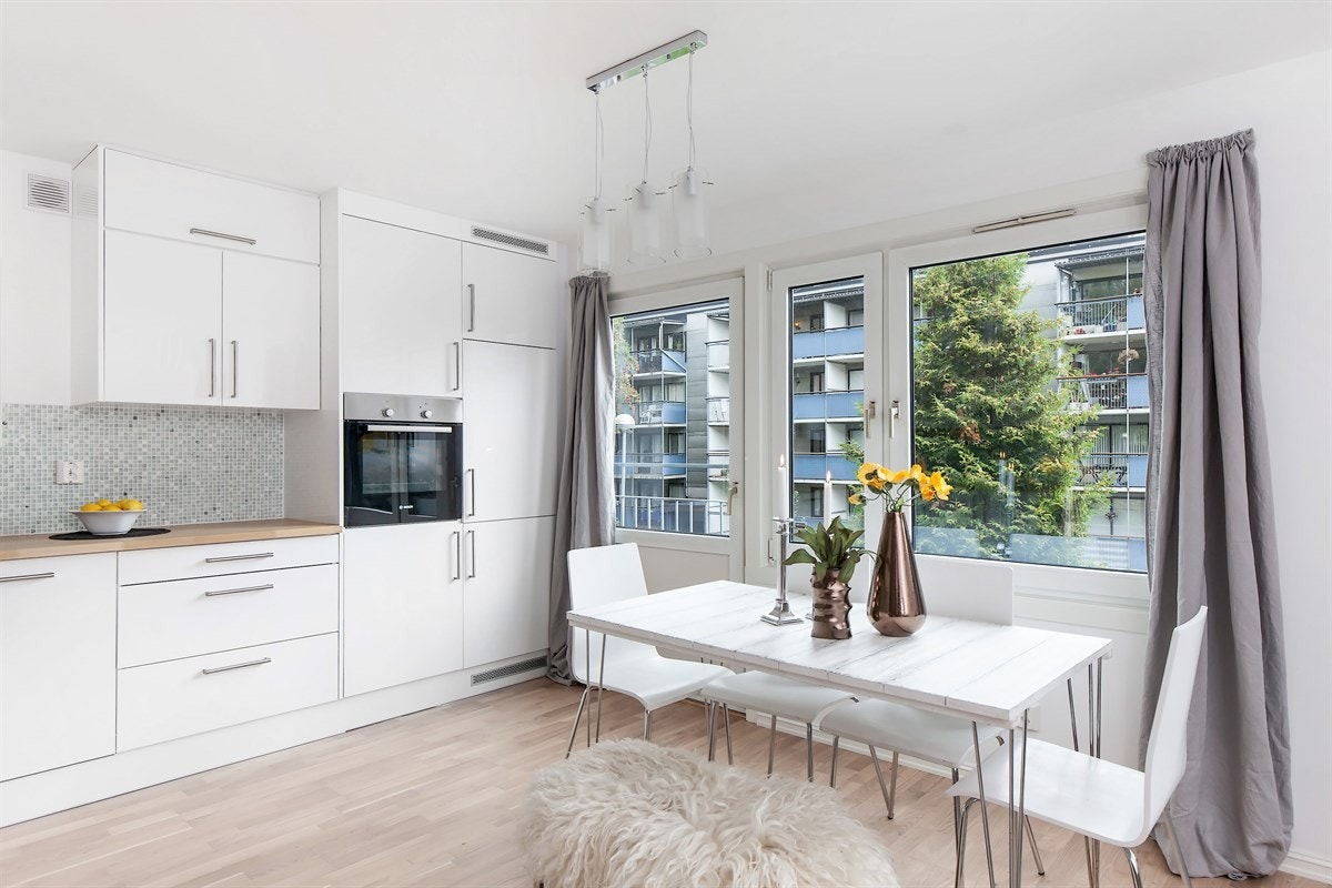 Innredningen har hvite høyglansfronter og benkeplate i heltre med dobbel vaskekum Galleribilde