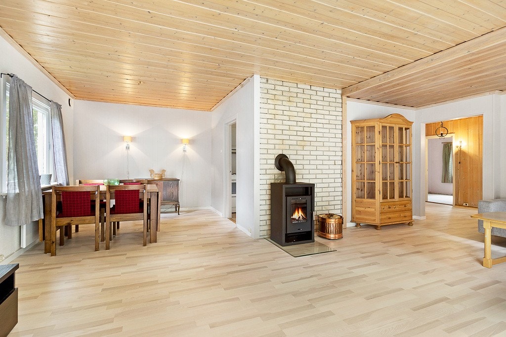 Stue med adkomst til spisestue fra kjøkkenet. Ny vedovn. Galleribilde