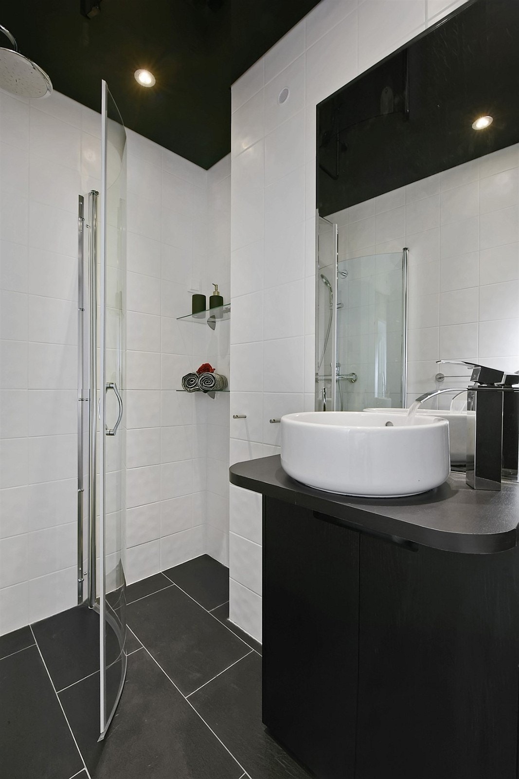 Badet fremstår som svært stilfullt og har mørke fliser på gulv og hvite fliser på vegg. Galleribilde