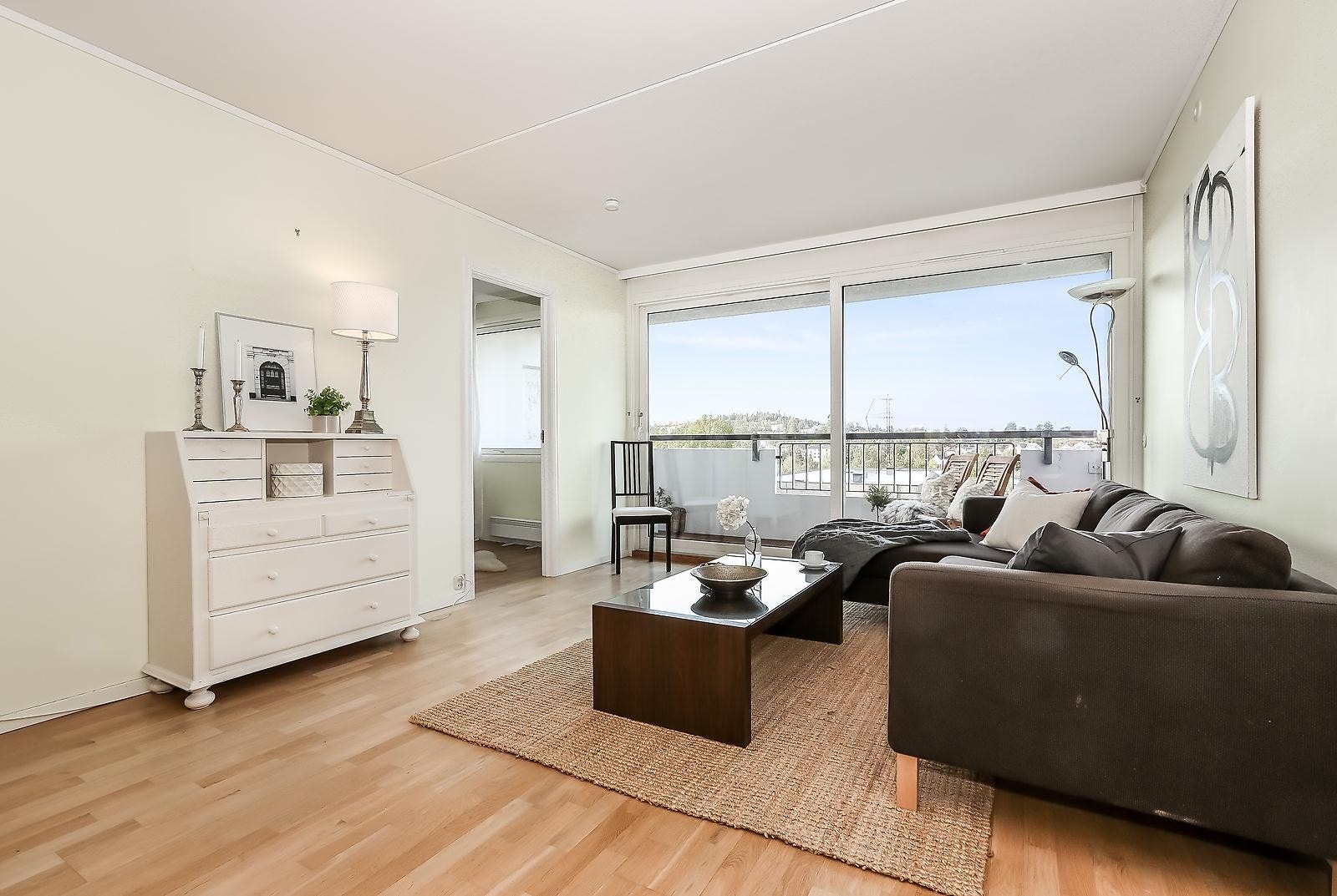 Stuen har store vindusflater som gir godt med lys til leiligheten Galleribilde