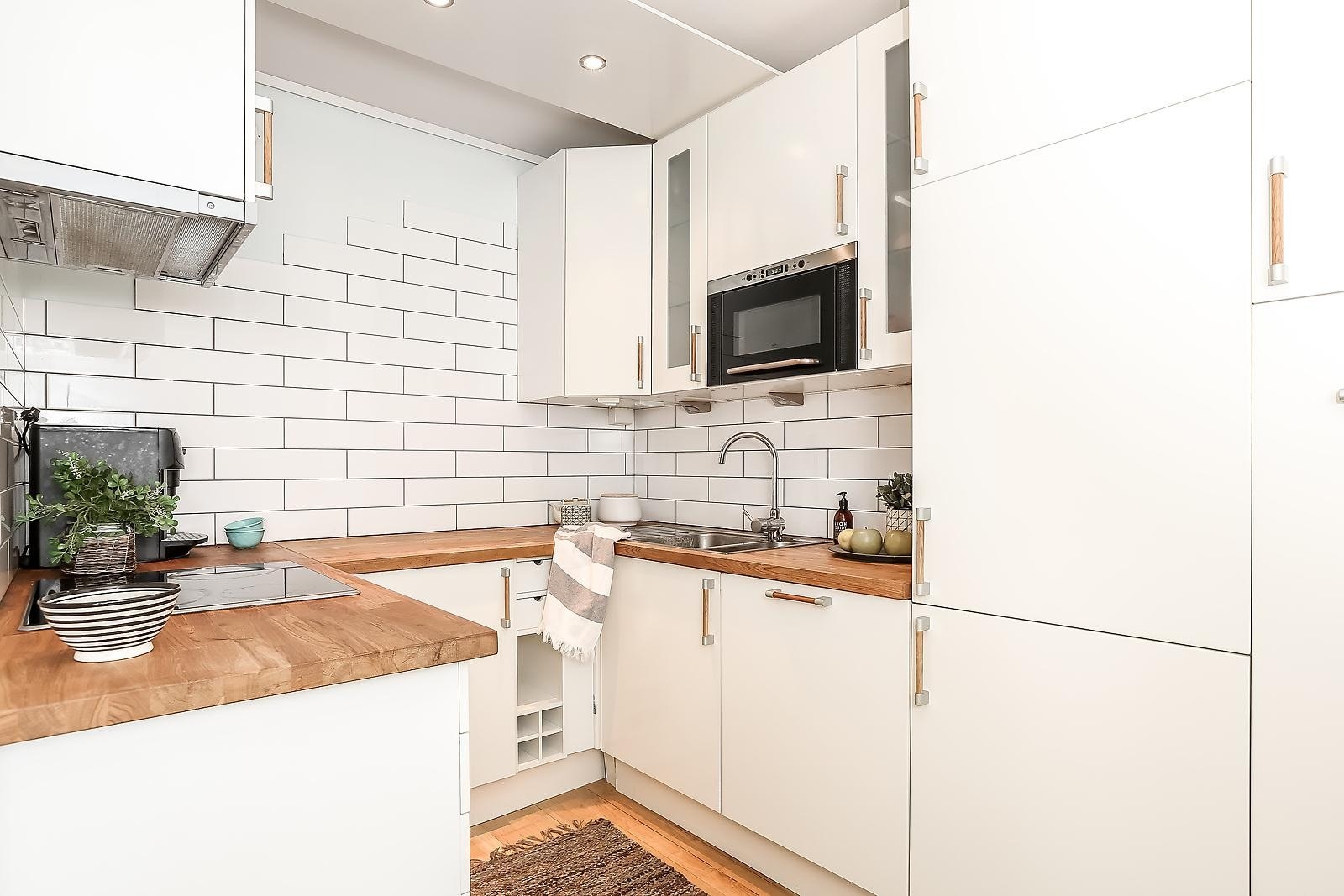 Kjøkkenet har en tidløs stil med integrerte hvitevarer Galleribilde