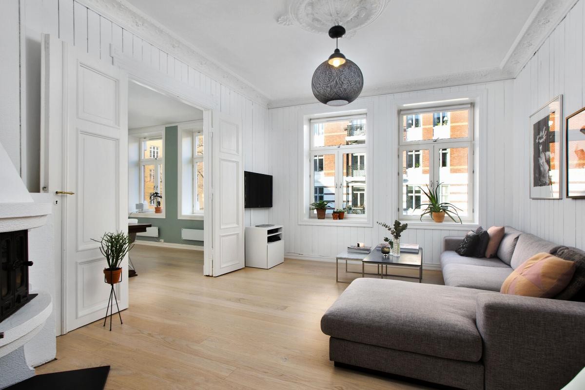 Lys og lekker stue med peis samt sjarmerende stukkatur og rosett Galleribilde