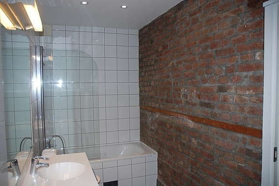 Bad, med badekar, dusj og fin rustikk teglvegg Galleribilde
