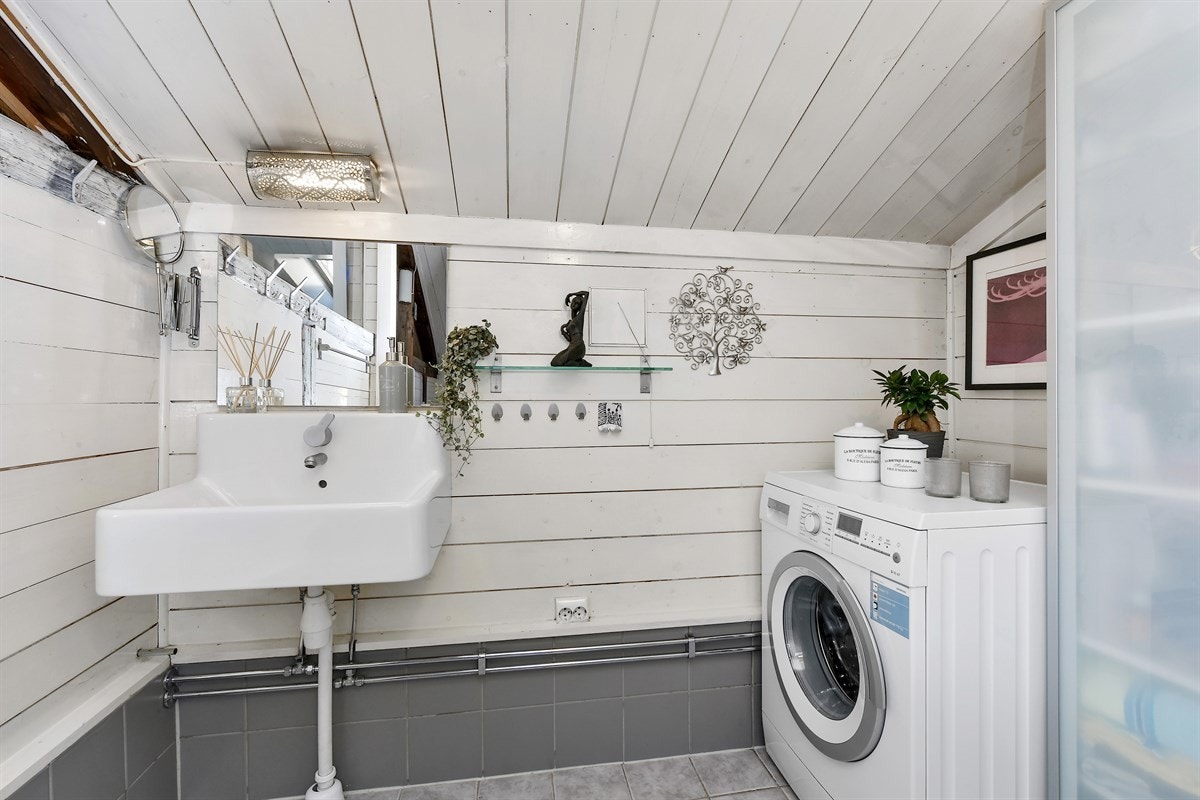 Badet i andre etasje fremstår som intimt og sjarmerende med synlige bjelker, skråtak og varierende materialvalg. Galleribilde