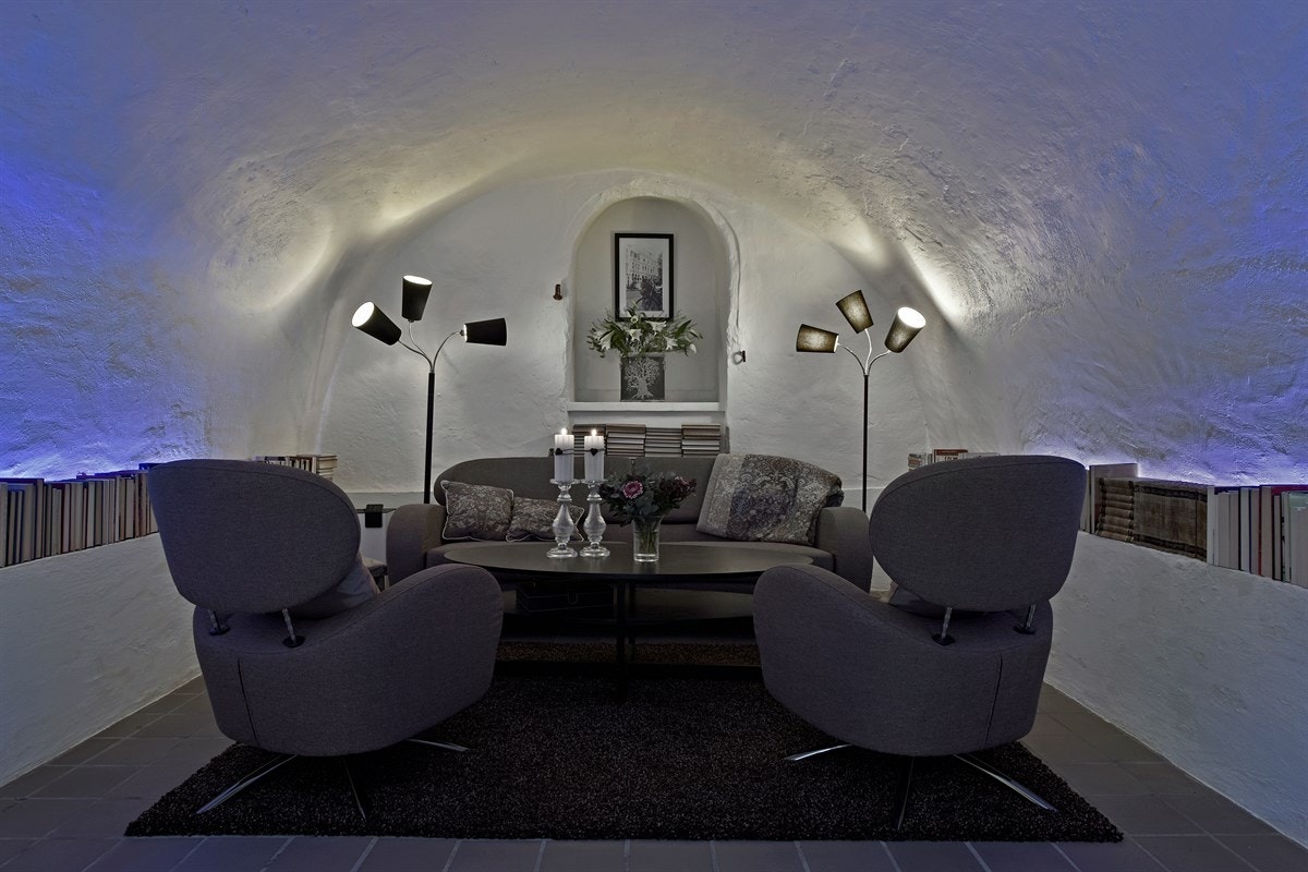 Her er det mørke fliser på gulv med gulvvarme, hvitmalte murvegger og pusset tønnehvelvtak som gir rommet et unikt særpreg. Galleribilde