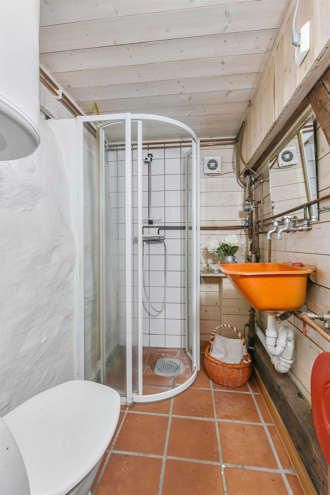 Bad nummer to har terrakottafargede fliser på gulv med gulvvarme, hvite murvegger, fliser i dusjsonen og panel på de øvrige veggene. Badet ligger i 1. etg, men i motsatt ende av kjøkken/spisestue. Galleribilde