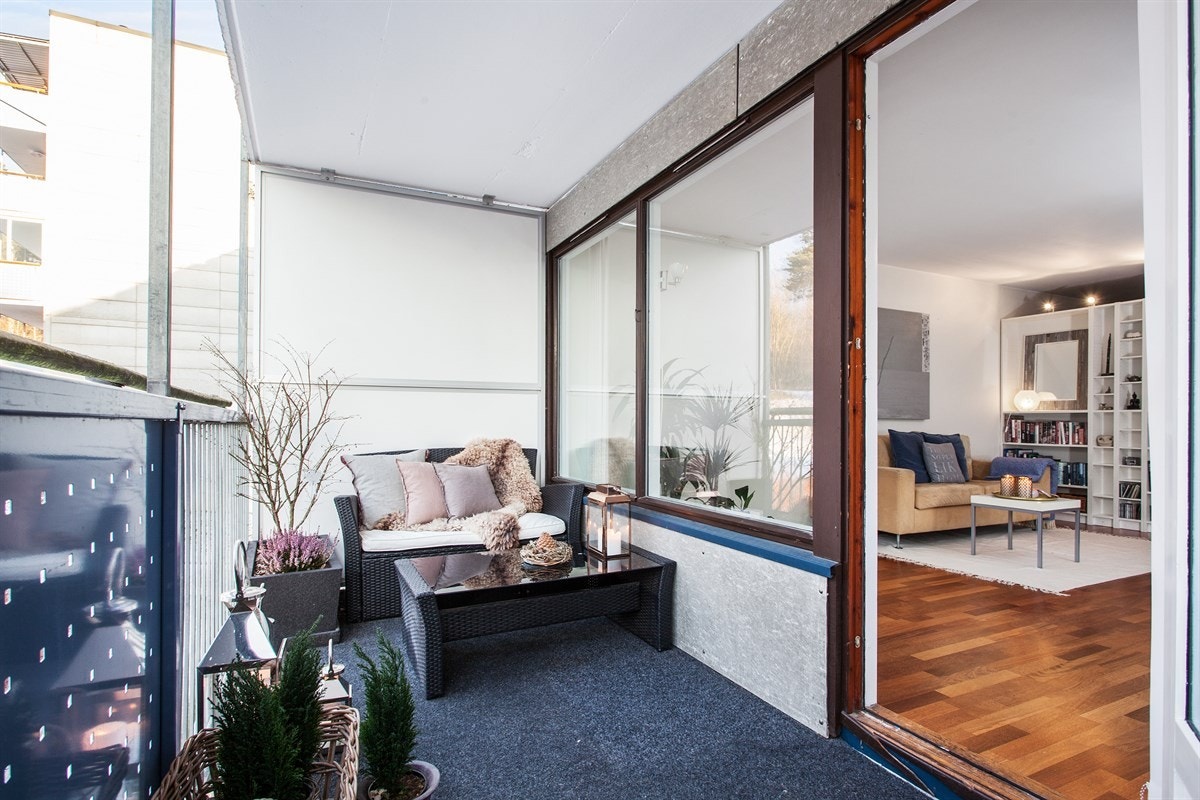 Stor, overbygget balkong med utgang fra stue. Balkongen har flott ettermiddags-/kveldssol og vender mot koselig skogholt Galleribilde