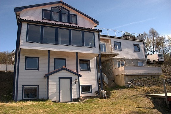 Fasaden med utsikt til sjøkanten, liten og lun balkong ved inngangspartiet. Galleribilde