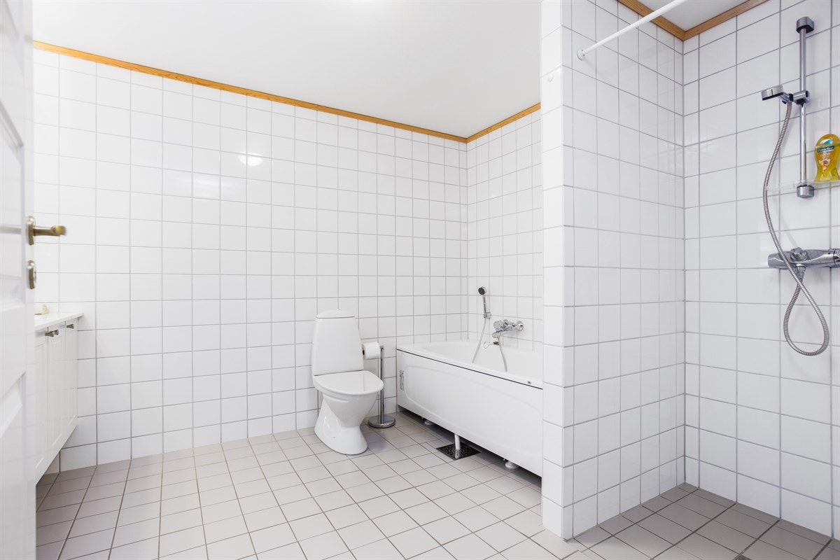 Badekar og adskilt dusjsone. Hvit baderomsinnredning med god oppbevaringsplass til baderomsartikler. Galleribilde