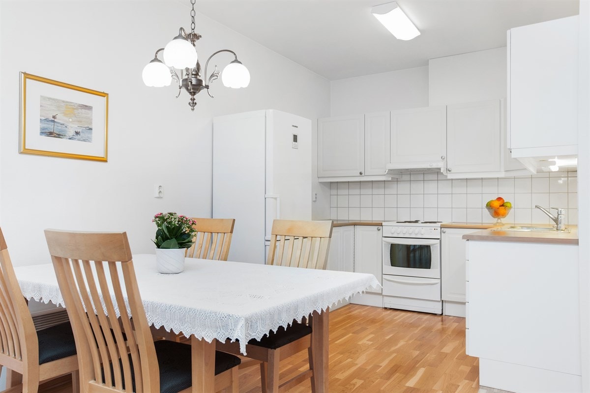 Kjøkkenet har åpen løsning og er naturlig adskilt av spiseavdeling. Hvit og stilren innredning. Galleribilde