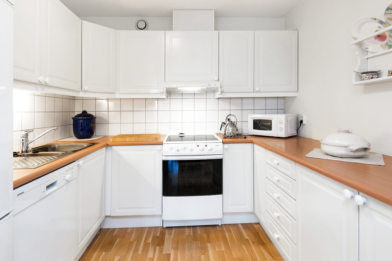 Lyst kjøkken av god størrelse, og her har du gode arbeidsflater samt godt med skapplass Galleribilde