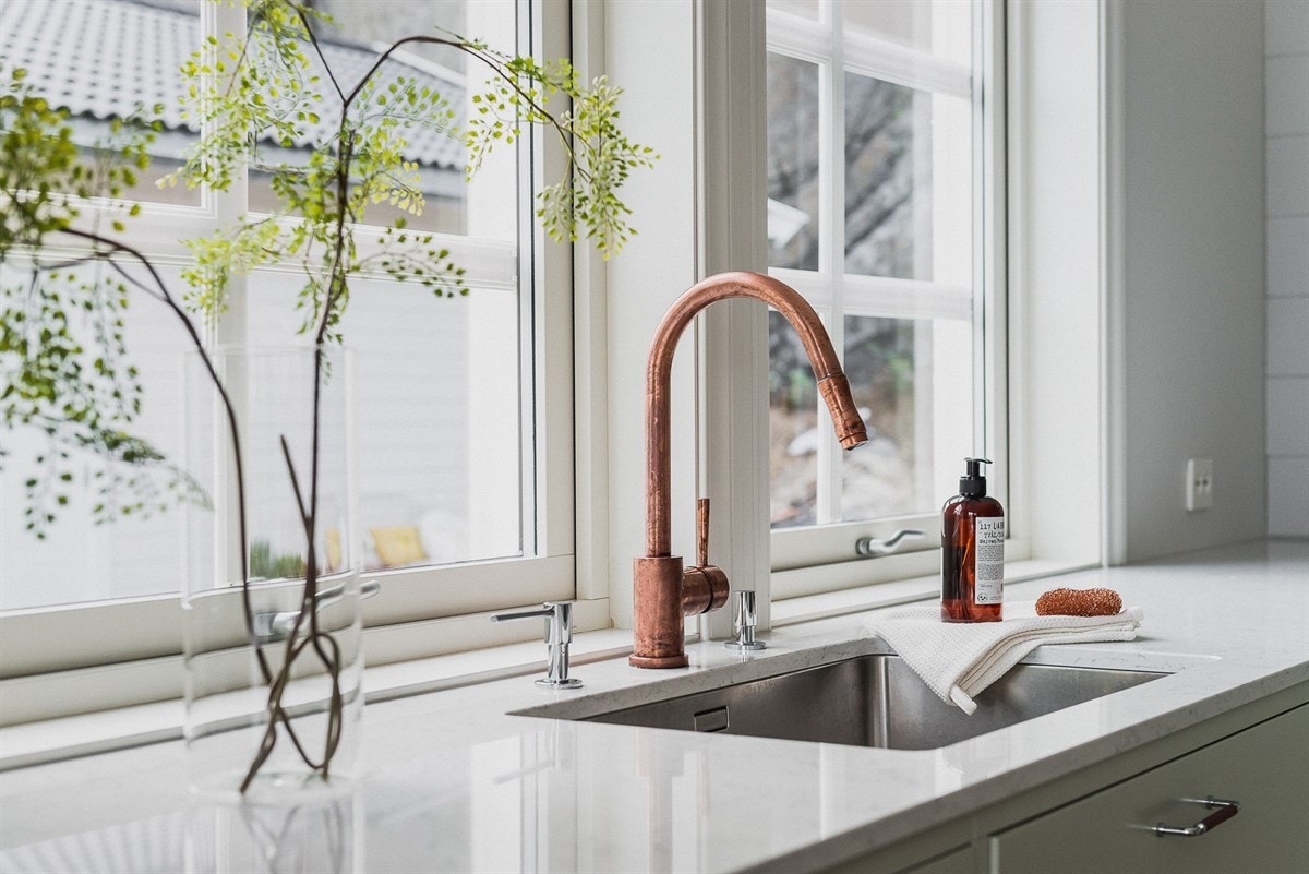 Legg også merke til kjøkkenarmatur i kobber, en tidsaktuell og skarp kontrast til det ellers lyse omkring. Galleribilde