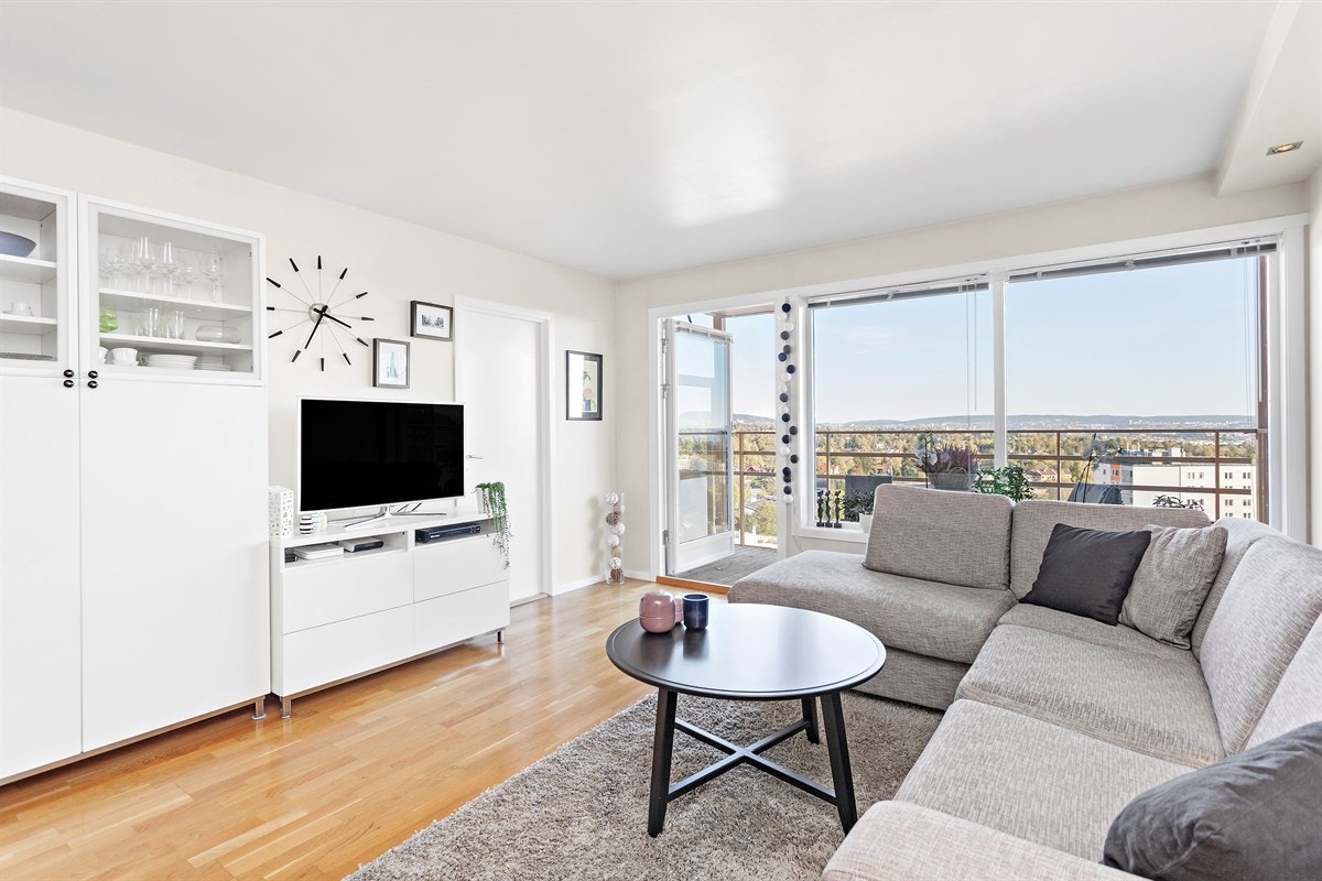 De store vindusflatene, lyse materialvalg og spotter i taket gir en lett og delikat stue. Galleribilde