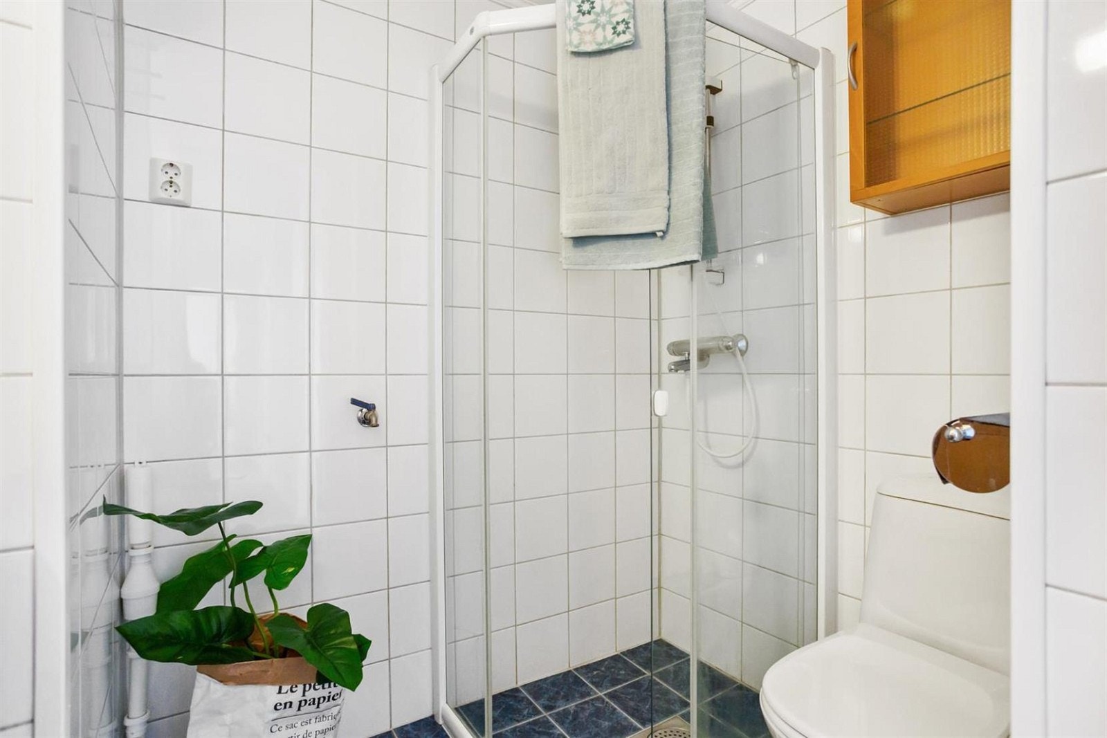 Badet har plass til vaskemaskin, dusjhjørne, wc og innredning med vask og speil. Galleribilde