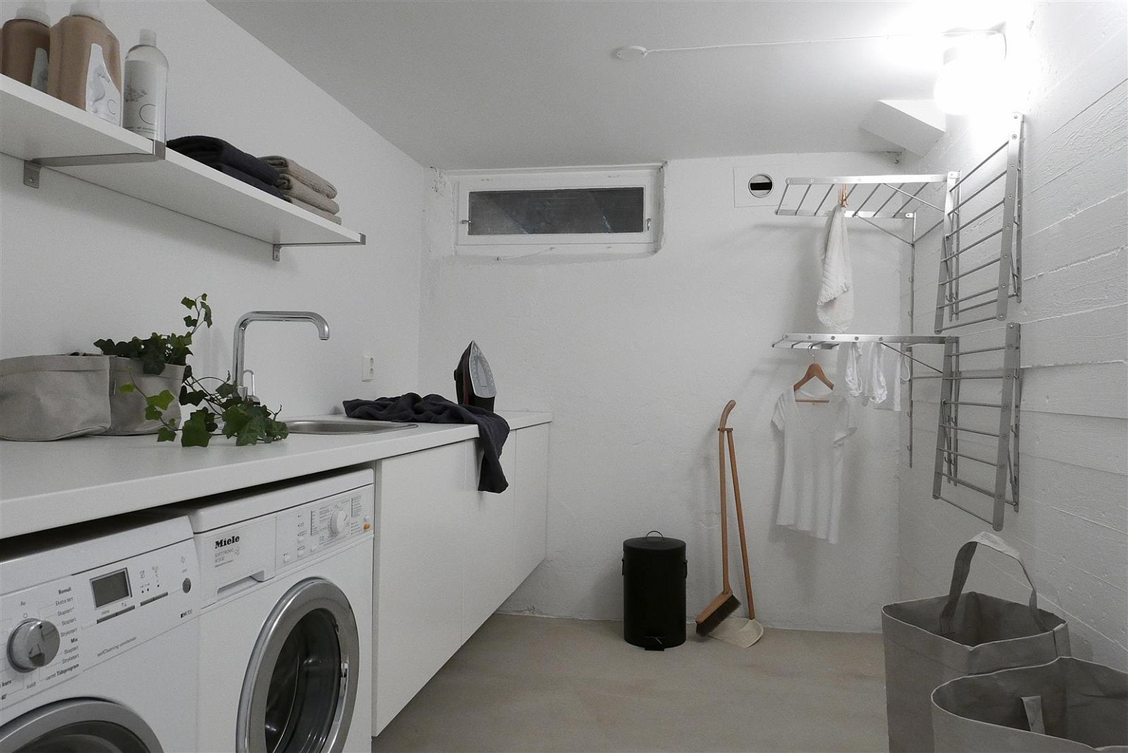 Vaskerommet i kjelleren er utstyrt med støpt gulv med gulvvarme, sluk og lysmalte vegger. Innredet med hyller, tørkestativ, benkeskap med servant og benkeplate, samt opplegg for vaskemaskin og tørketrommel. Oppgradert i 2016. Galleribilde