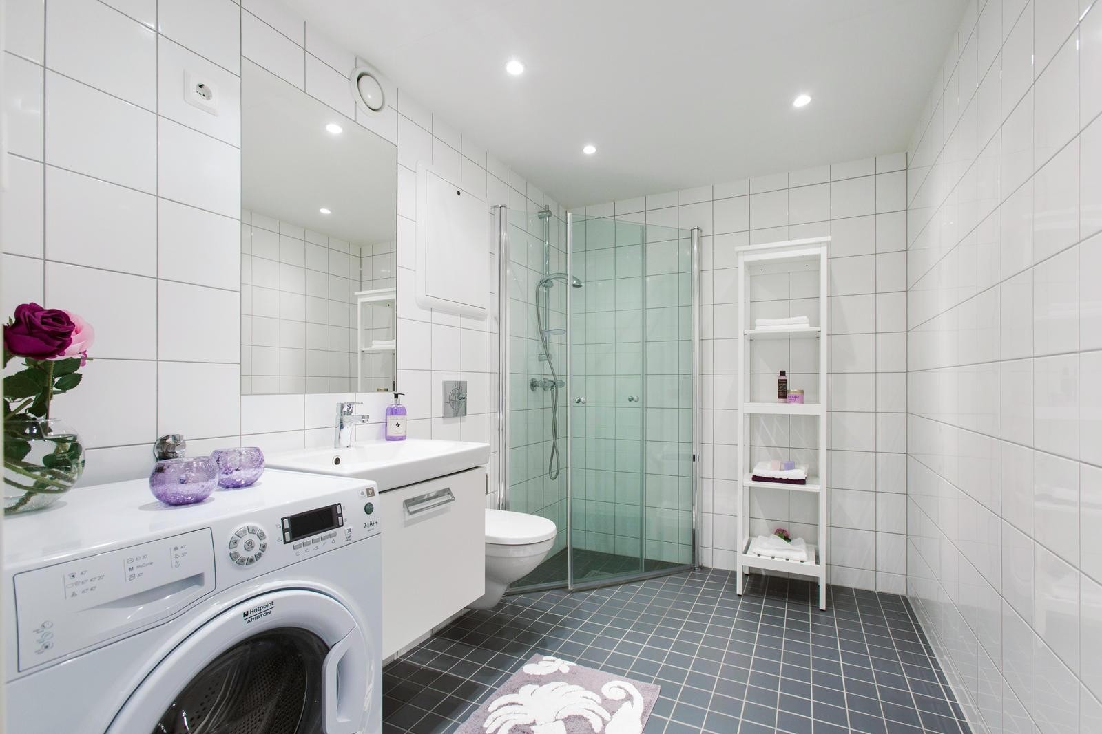 Delikat fliselagt bad med dusjhjørne, vegghengt toalett og opplegg for vaskemaskin. Downlights i tak. Galleribilde