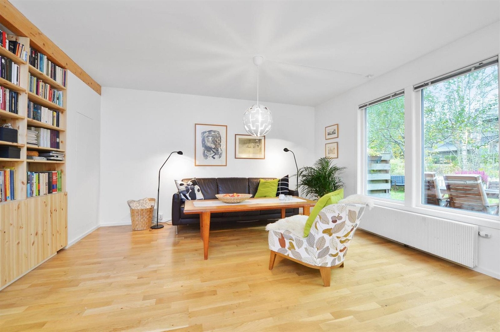 Plass til sofagruppe og gode oppbevaringsmuligheter i en integrert bokhylle. Galleribilde