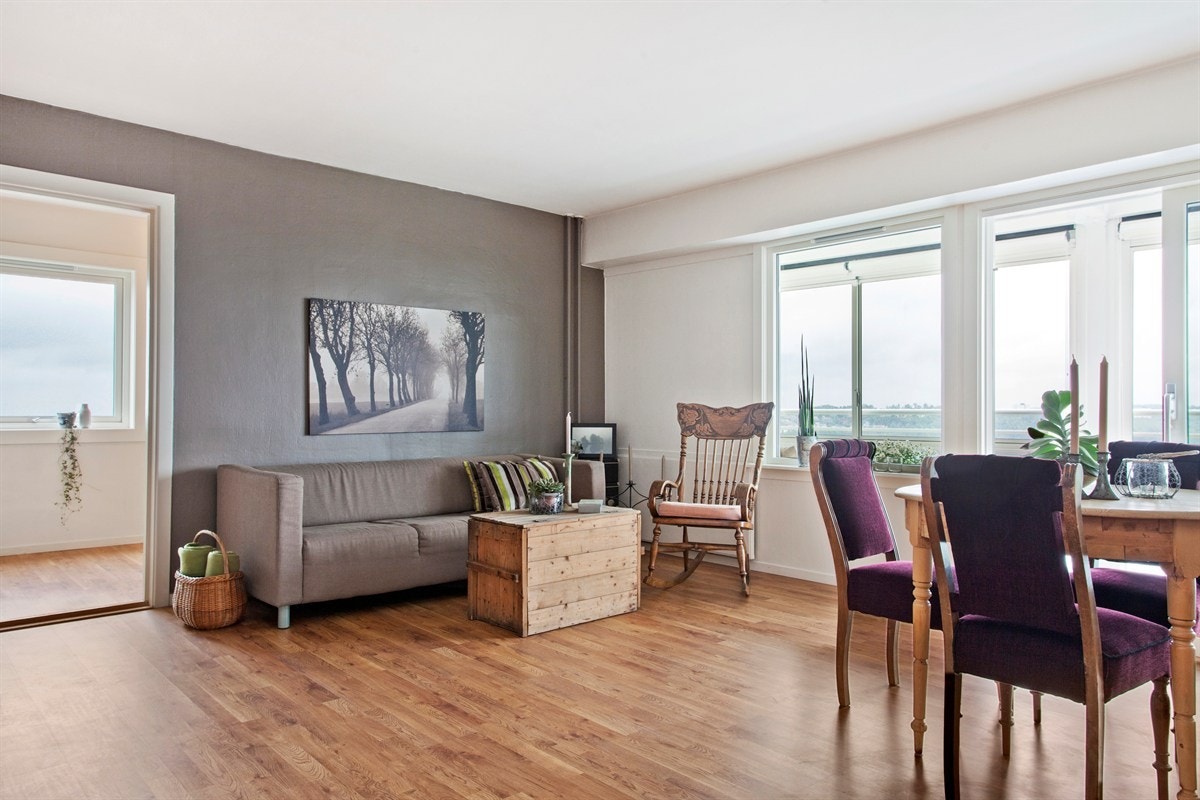 Stuen fremstår i lyse farger med store vinduer som gir mye lys Galleribilde