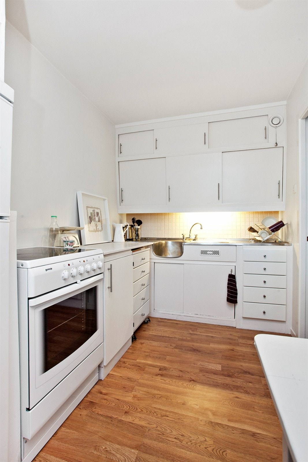 Kjøkken med malt original innredning og laminatgulv Galleribilde