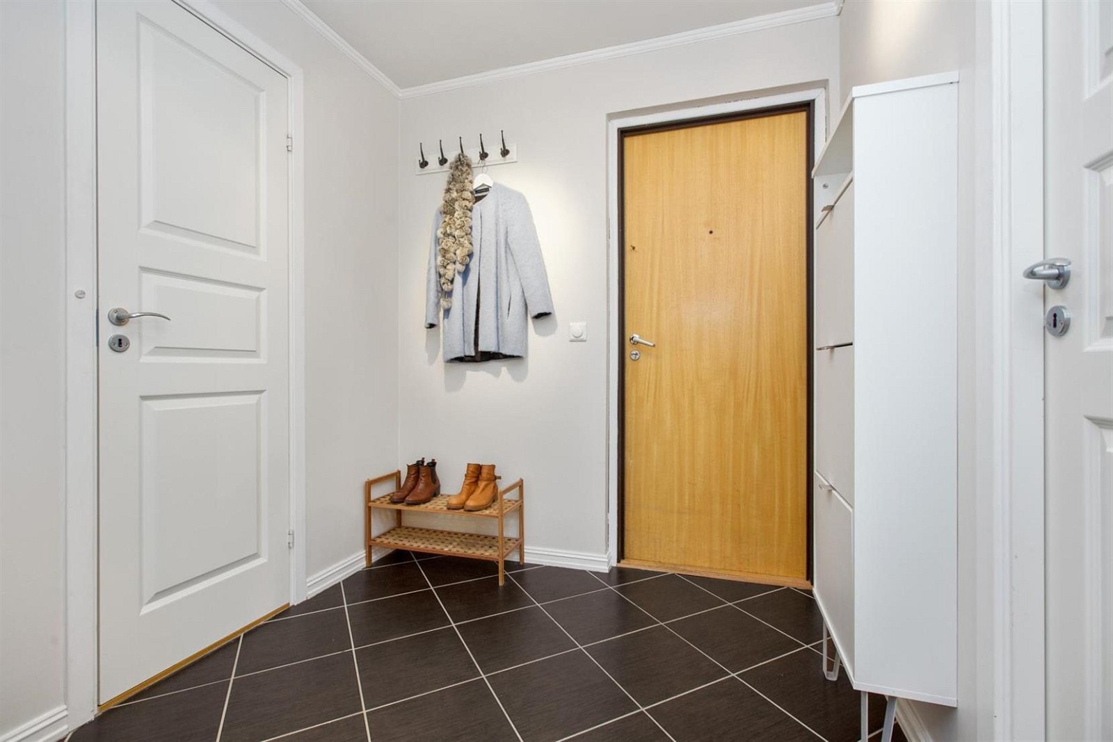 Romslig entré med fliser på gulv. Galleribilde