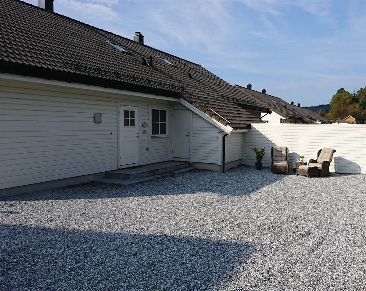 Baksiden av huset. Like ved inngangsdøren ligger sportsboden med plass til både sykkel, ski og akebrett. Galleribilde