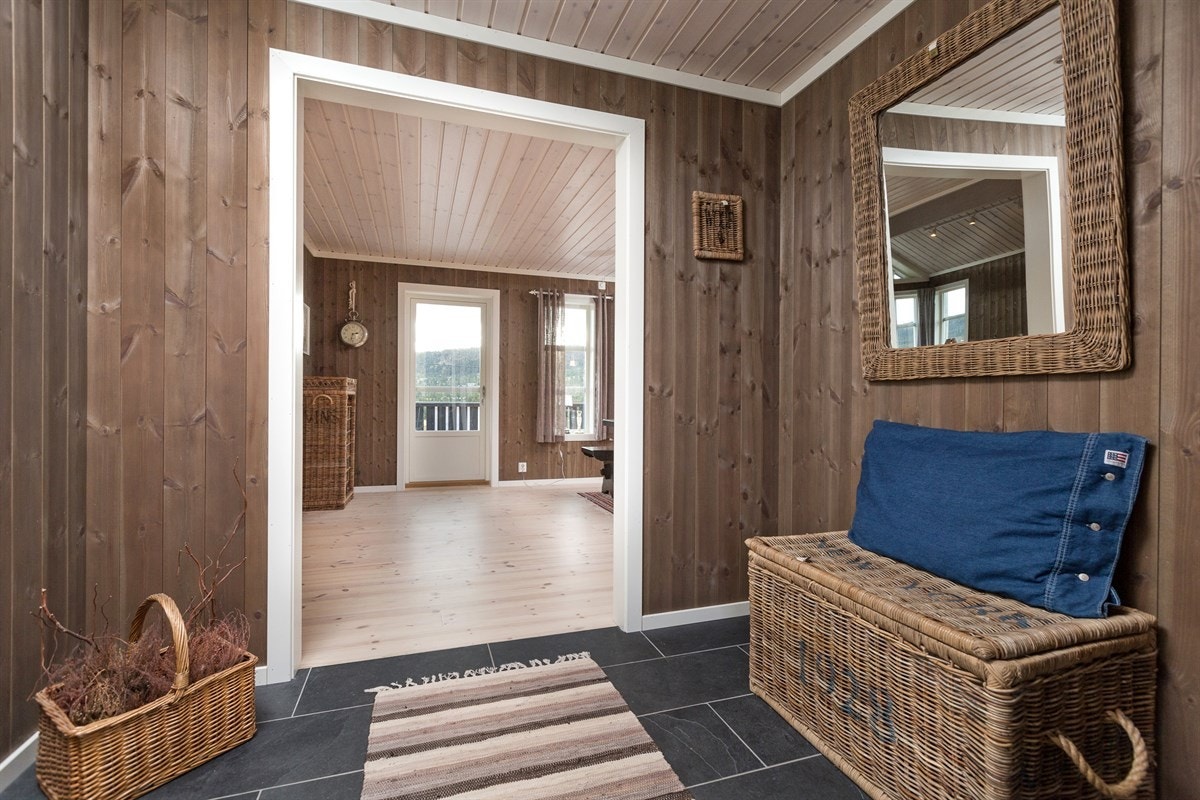 Entrè med varme og fliser på gulv. Behandlet furupanel på vegg setter den koselige hytte-standarden for resten av hytta. Galleribilde