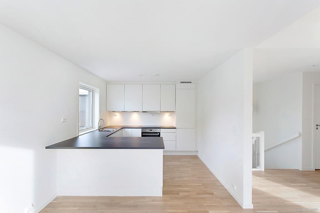 Moderne, lys og praktisk kjøkkeninnredning med skap som går helt til tak. Integrerte hvitevarer som medfølger i handelen. Galleribilde