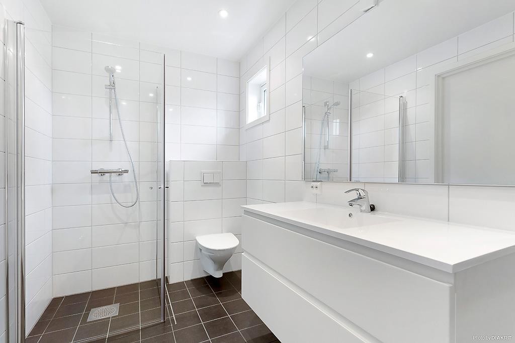 Fint baderom i 1. etasje med stort speilskap, servant, dusj og vegghengt toalett. Galleribilde