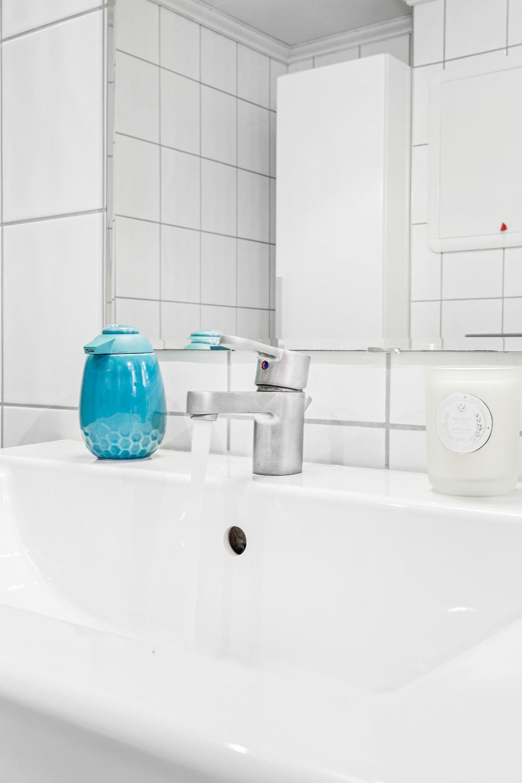 Pent helfliset bad som inneholder servantmøbel, speilskap, vegghengt toalett, dusjhjørne og høyskap. Her er det opplegg for vaskemaskin. Galleribilde