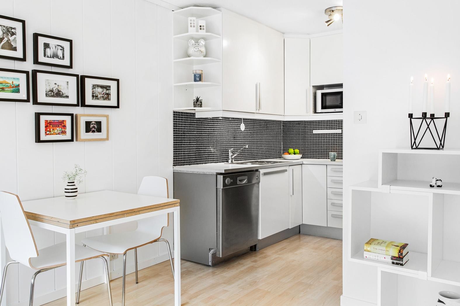 Lyst og fint kjøkken fra ca. 2008 med hvite profilerte fronter og kjøkkenfliser Galleribilde