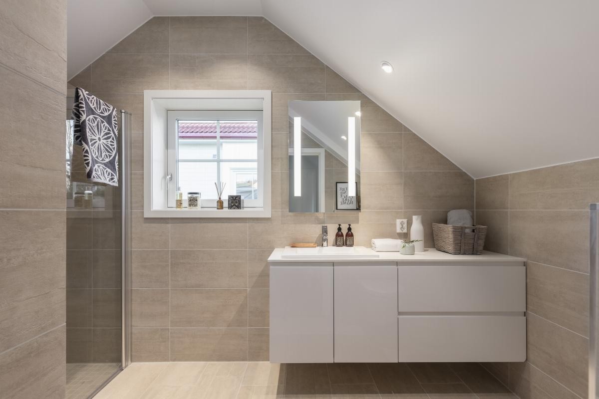 Delikat bad med smakfulle fliser på gulv og vegg Galleribilde