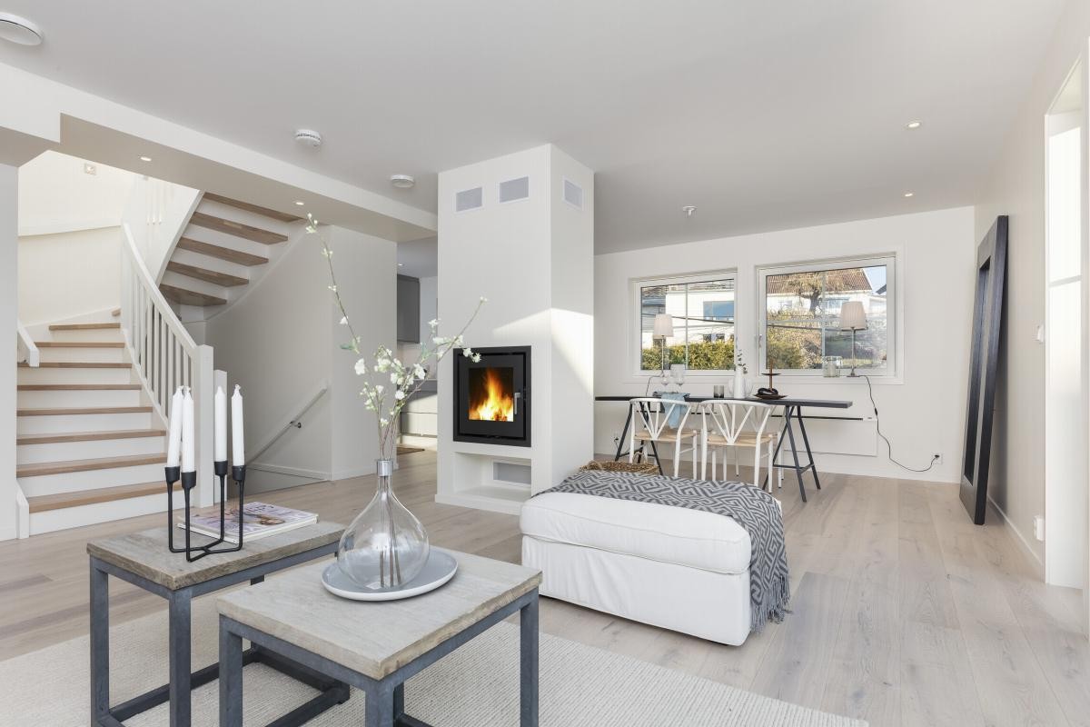 Stuen har en flott og åpen romlayout med peis, utgang til terrasse og god plass til både salong og spisegruppe Galleribilde