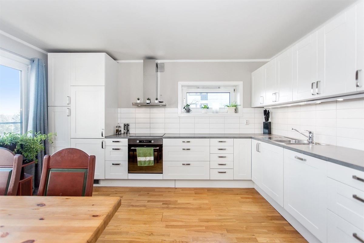 Nyere, moderne kjøkkeninnredning med god skap-/benkeplass og integrerte hvitevarer Galleribilde